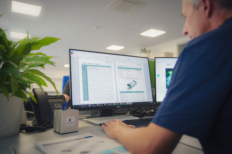 Mitarbeiter von Reiter Österreich plant Lineartechnik-Komponenten am Computer und bietet technischen Service und Beratung.