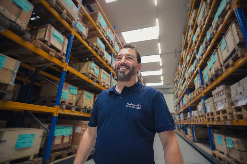 Freundlicher Reiter-Mitarbeiter im Lager unterstützt Kunden beim sicheren und schnellen Beschaffungsprozess von Produkten.