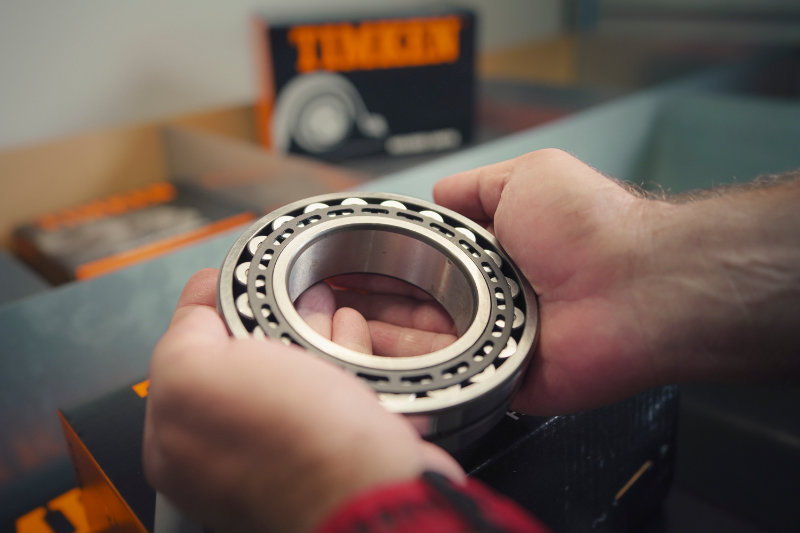 Hochwertiges Timken-Wälzlager wird von einem Mitarbeiter geprüft – starke Partner RKB und Timken für Normteile und Lagertechnik.
