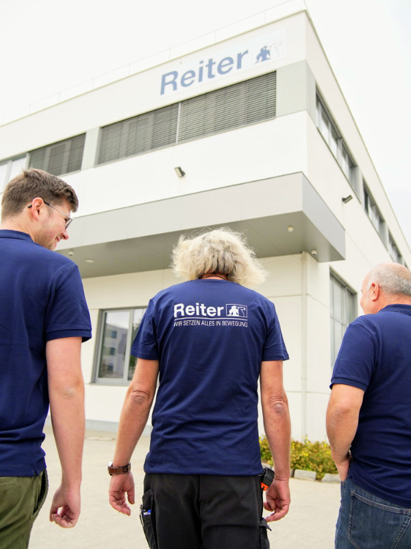 Reiter Mitarbeiter gehen auf das Firmengebäude in Wien zu – Team eines führenden Technikunternehmens für Maschinenbau in Österreich