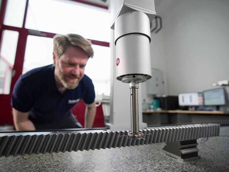 Reiter Techniker an der Leitz Messmaschine bei der präzisen Kontrolle einer geschliffenen Zahnstange mit Schrägverzahnung in der Verzahnungstechnik